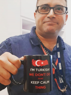 Seref at the BBC holding a mug that says "I'm Turkish! We don't do that keep calm thing".