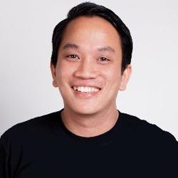 Young man looking and smiling at the camera in a black tshirt