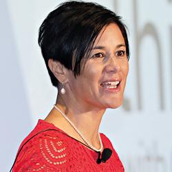 Woman with short hair and red dress speaking while looking off camera