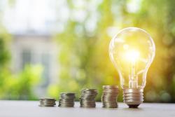 Light bulb next to coins