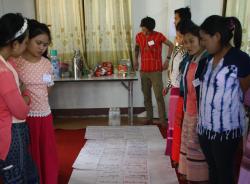 Women standing looking at large paper chart on the floor