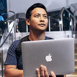 Man in stairwell holding laptop