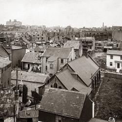 Black and white view over old cluttered rooftops
