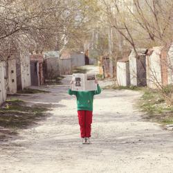 A person holding up a newspaper in regional street