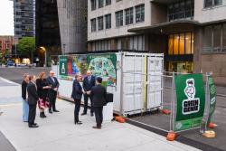 Minister Tanya Plibersek with UTS staff looking at a poster for Green Genie on campus