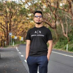 A man stands at a forest roadside.