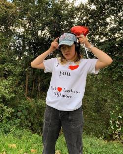 Female student wearing baseball cap, headphones and white t-shirt that reads 'I love you but I love Izzybops (DJ) more'