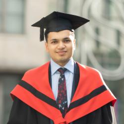 Man wearing red graduation hood and black mortarboard.