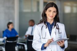 Doctor with clipboard looking at the camera