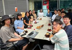 Students gathered at a long table with coffees