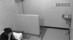 Sorry for your loss. woman sitting in her bed in her prison cell with her hands over her forehead