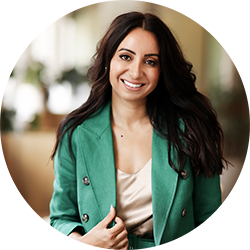 Woman with long brown hair smiling and looking at the camera wearing a green jacket