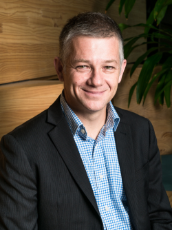 Man in a blue checked shirt and a grey suit