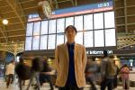 A man stands in front of a train schedule