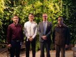 A group of people in front of a vertical garden