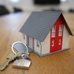 Toy House sitting on a table with House keys beside it