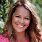 headshot image of woman smiling at the camera - she is wearing a pink shirt