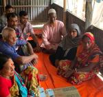 Women and men sitting around a mat with a planning board