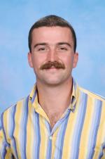 image of young male in striped shirt smiling at camera