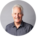 A portrait photo of Stuart White. He has grey hair and is smiling.