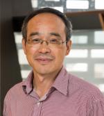 Chest up photo of John Zhou smiling softly at the camera