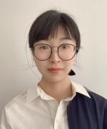 Chest up image of Wei Wei with a jacked draped over her left shoulder looking at the camera