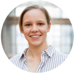 Isabelle Schaefer is wearing a striped shirt. Her hair is tied back and she is smiling at the camera.