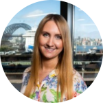 Jane Oja smiling facing the camera with the Sydney harbour in the background