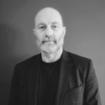 Andy West in a black T shirt and business jacket